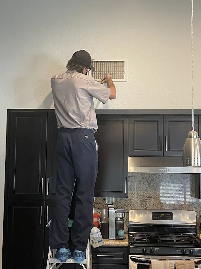 Technician inspecting an air vent during HVAC service in Lincoln Park